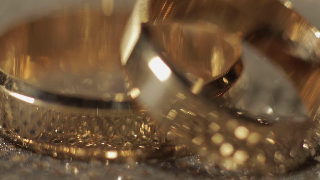 свадебные кольца лежат на блестящей глянцевой поверхности. блестящие светом. крупный план