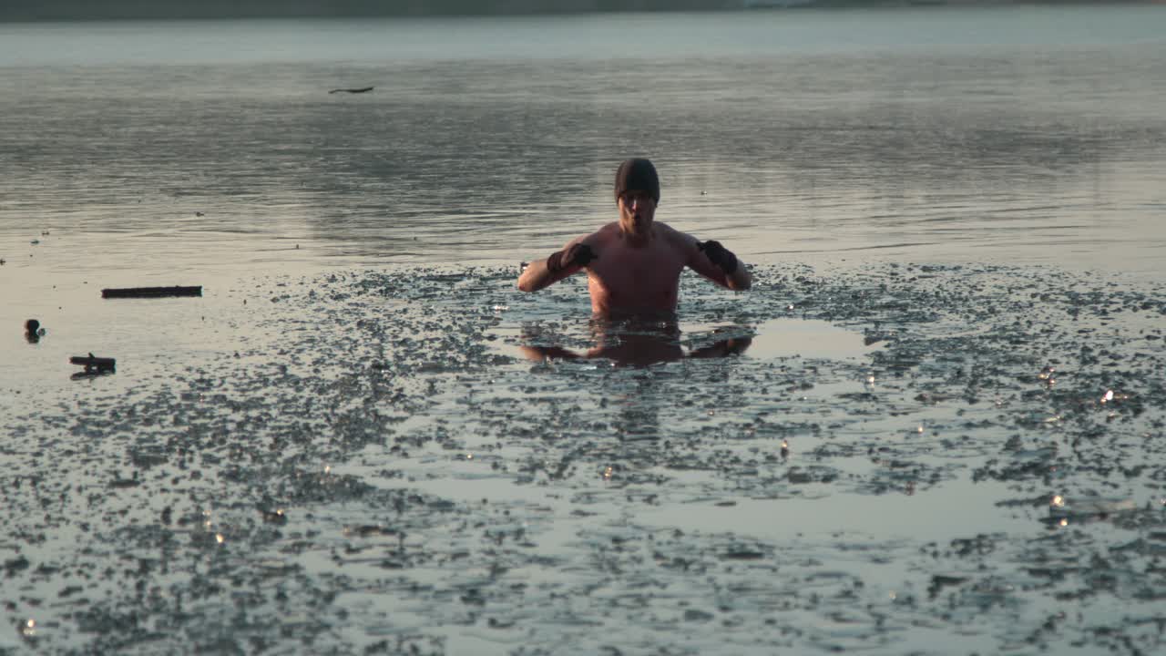 un joven saliendo de un lago congelado después de nadar