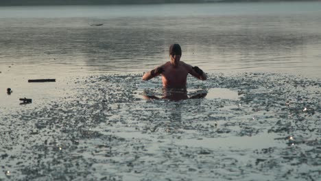 a young man coming out of a frozen lake after swimming