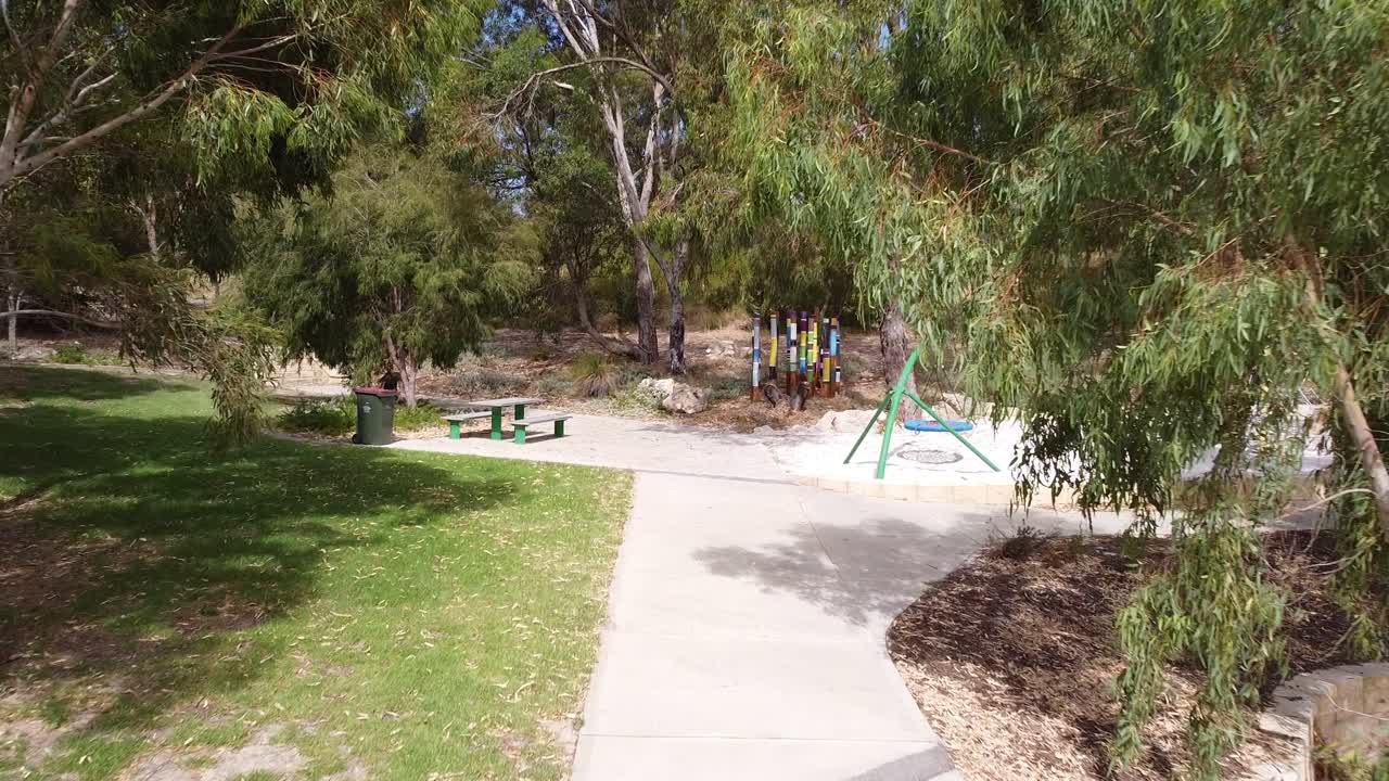 Walking path surrounded by foliage leading to seat and child&rsquo;s play area
