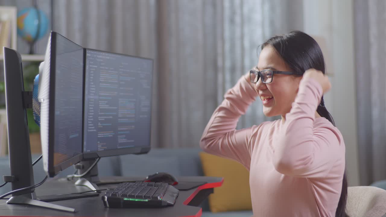 chica adolescente asiática programadora celebrando éxito en la creación de ingeniero de software desarrollando aplicación, programa, videojuego en la computadora de escritorio en casa. terminal con lenguaje de codificación