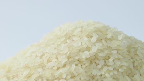 macro white raw rice texture, food background, vegetarian healthy eating product. rotating close up of a pile of raw rice