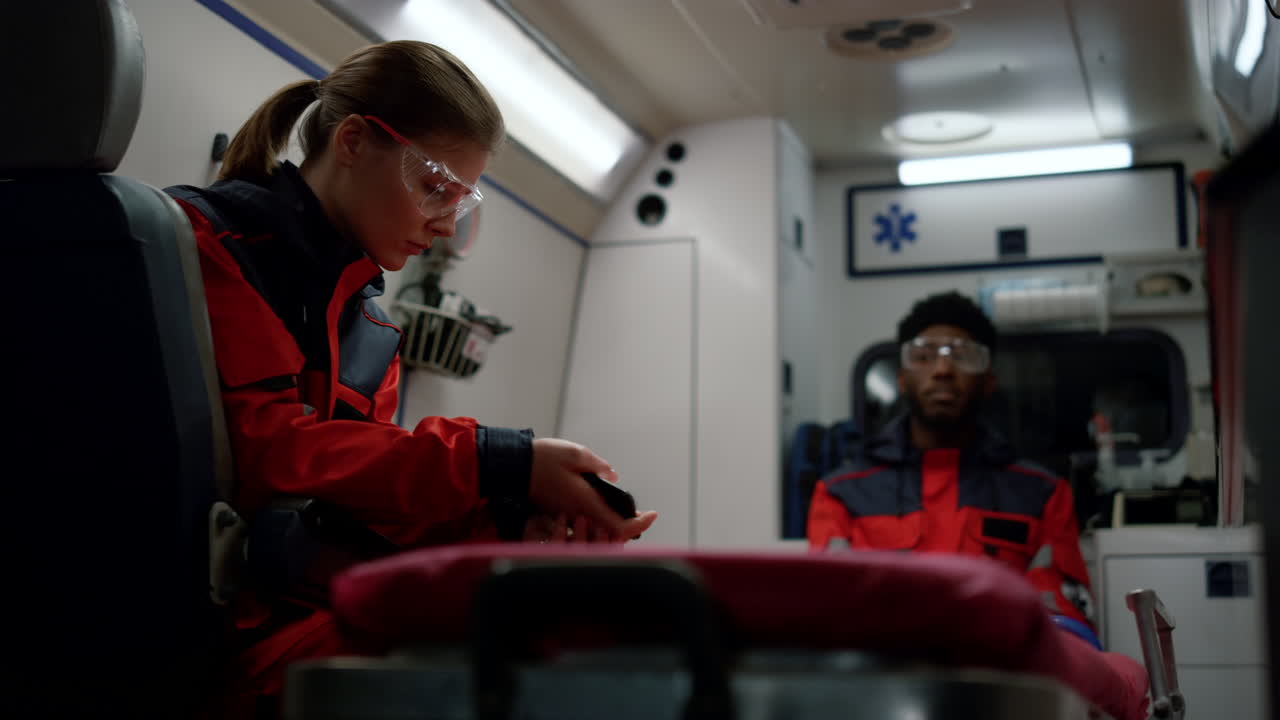 의료 전문가 들 이 구급차 에서 응급 전화 를 받기 위해 가고 있다