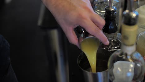 Gießen-Sie-Orangensaft-In-Ein-Messglas-Und-Einen-Shaker,-Der-Einen-Cocktail-Im-Nachtclub-Zubereitet