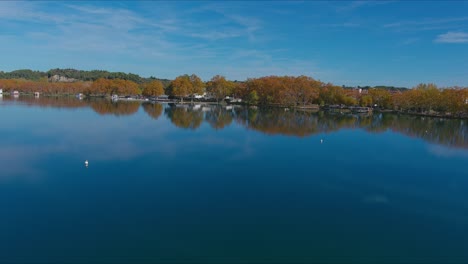 Drone-approaching-edge-of-Lake-Banyolas-where-there-are-docks-and-piers