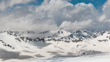 vuelo aéreo a través de nubes montañosas sobre hermosos picos nevados de montañas y glaciares.