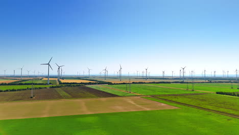flight over the picturesque countryside with wind farms. green energy being produced by wind turbines