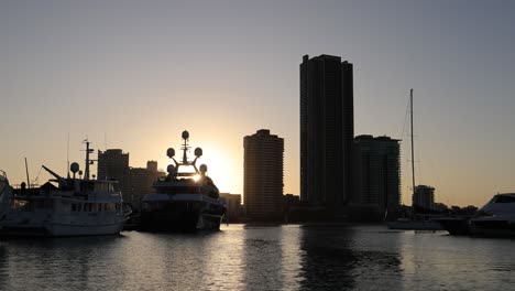 time-lapse of sunset behind yachts and city buildings