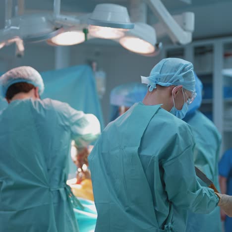 process of trauma surgery operation. group of surgeons wearing protective masks. medical and saving lives concept