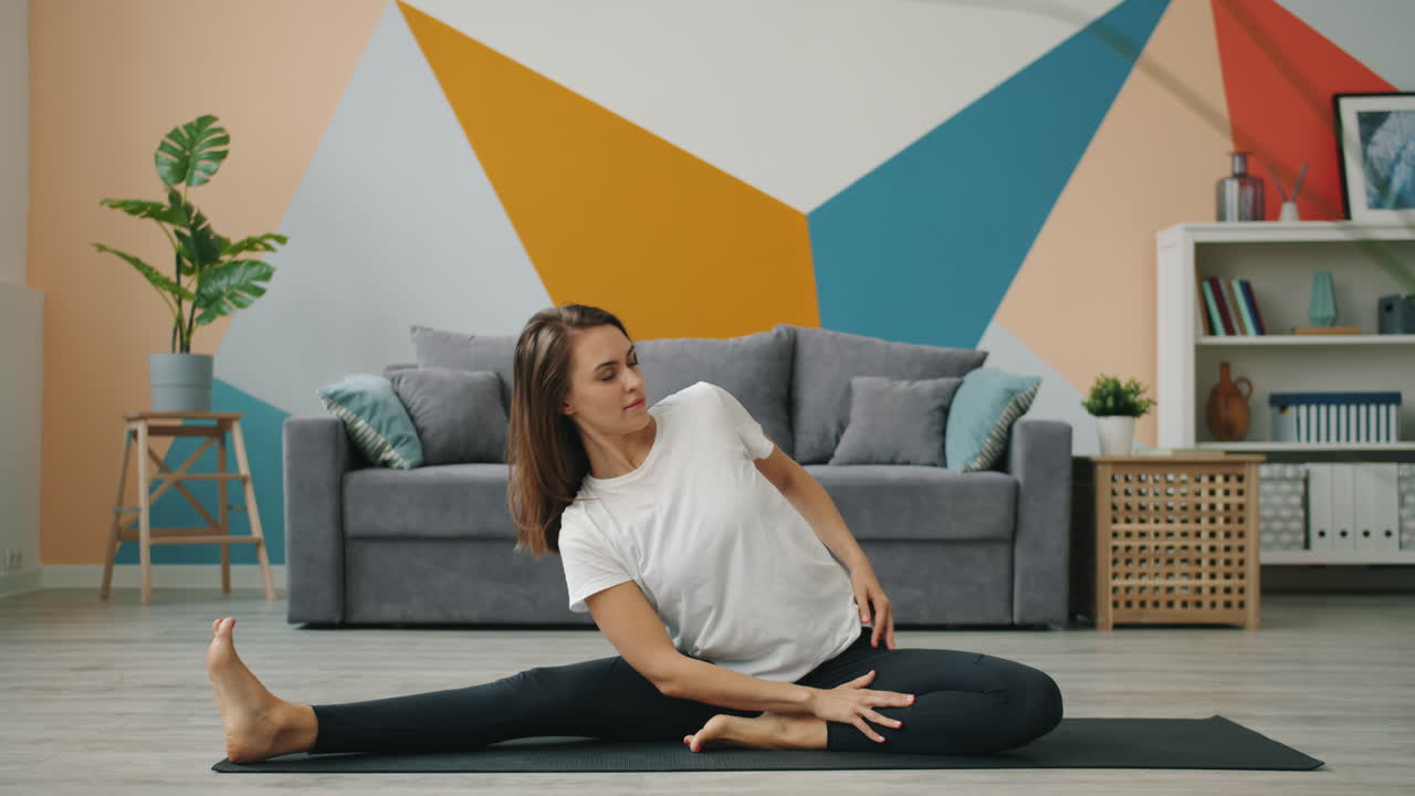 가정 에서 요가 자세 를 연습 하는 여자