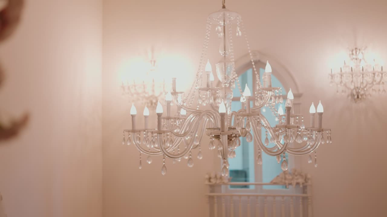 luxurious crystal chandelier lit in soft ambient light inside elegant wedding venue