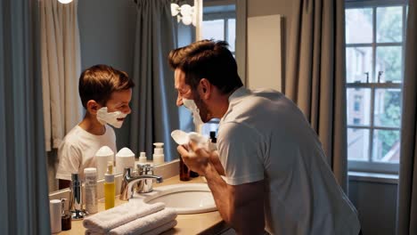 father and son shaving in the bathroom