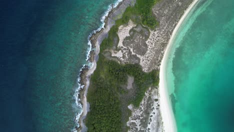 aerial top-down view of a tropical island with turquoise waters and lush greenery