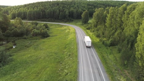 truck on a winding country road through forest