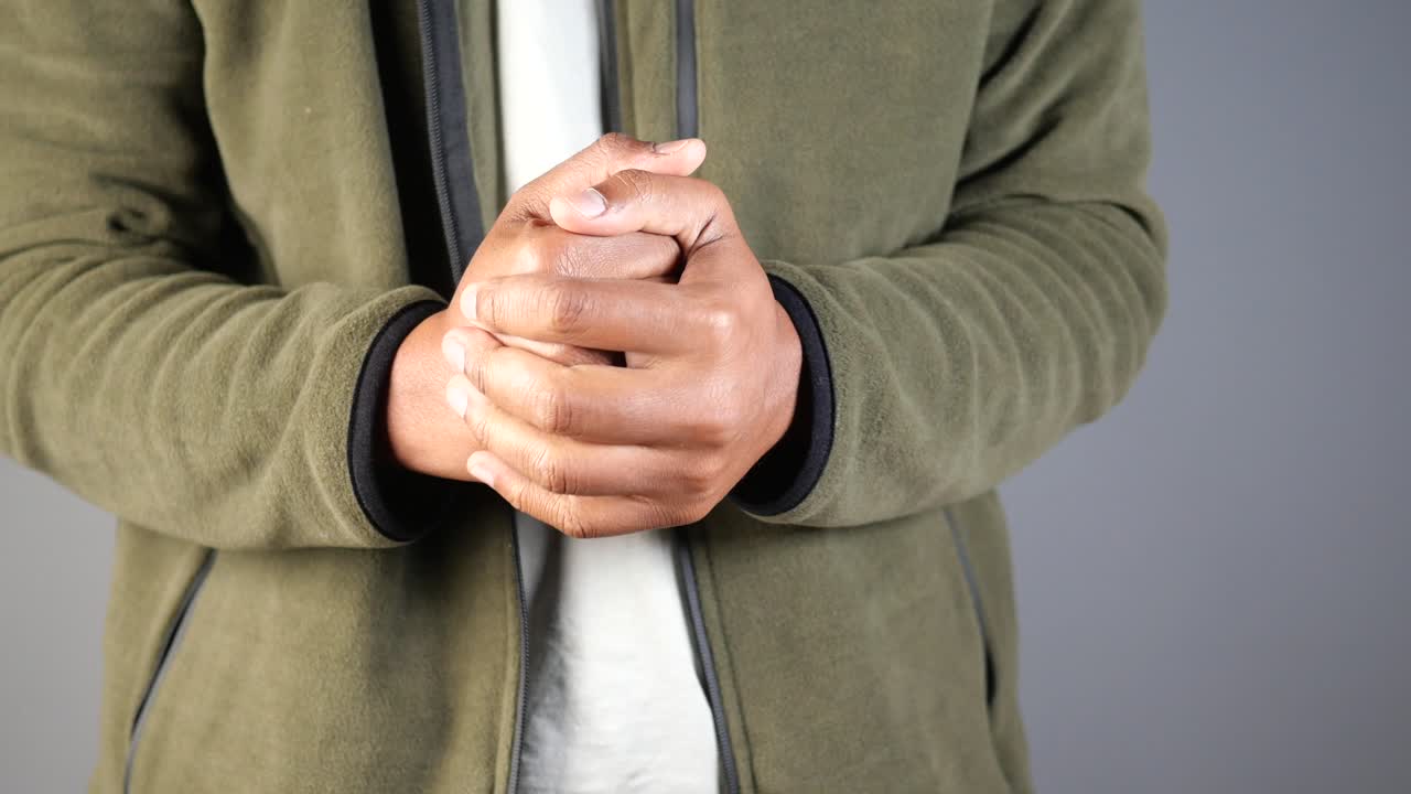 Man Rubbing Hands in Fleece Jacket