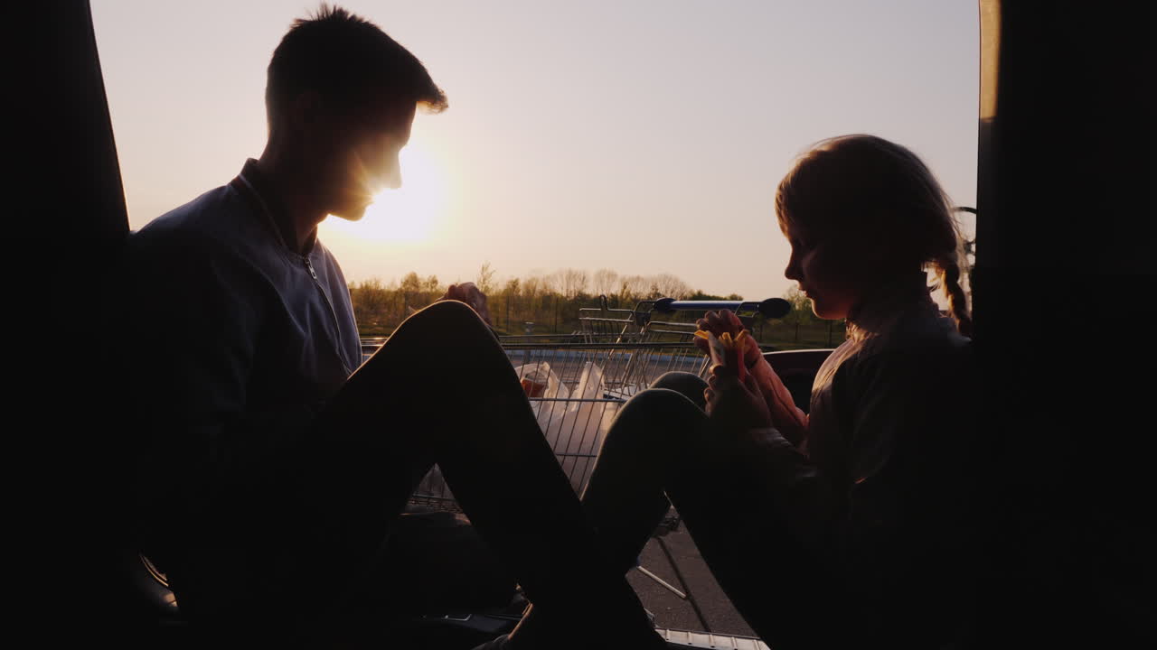 여동생이 있는 십대는 자동차 여행에서 주유소 휴식에서 간식을 먹을 것입니다