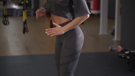 Step-platforms.-Girl-in-sports-grey-leggings-and-top-doing-exercises-for-aerobics.-The-concept-of-tightening-in-the-gym-for-weight-loss.-Aimed-footage-of-woman's-torso