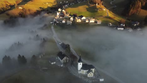 Imágenes-De-Drones-De-Un-Pueblo-Alpino-En-La-Niebla-De-La-Mañana