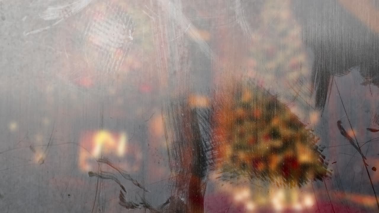 Frosty window with blurred Christmas tree and fireplace in background. Festive winter scene. Seamless loop