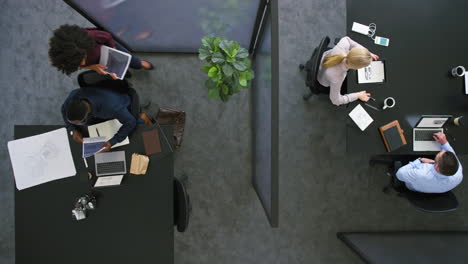 aerial view of architects using blueprints to