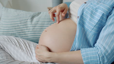 임신 한 여자는 그녀의 아랫 배를 만지고