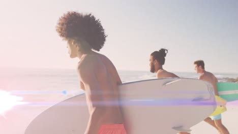 Animation-of-light-over-happy-diverse-male-friends-running-on-beach-with-surfboards