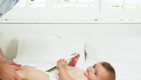 Happy-father-playing-with-his-baby-on-a-bed