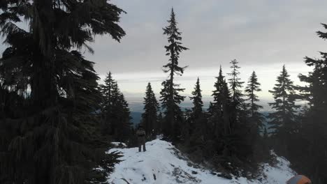 Toma-Aérea-De-Una-Persona-En-La-Cima-De-La-Montaña-Grouse-Contemplando-La-Vista-De-Vancouver-Columbia-Británica-Al-Atardecer