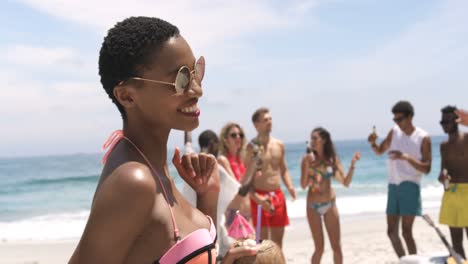 Front-view-of-African-American-woman-dancing-on-the-beach-4k