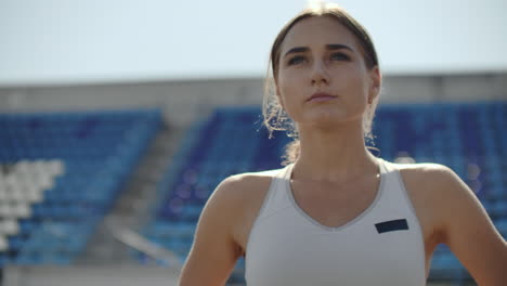 slow motion: athlete woman waiting in the starting block on running track