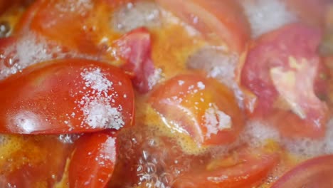 cooking sliced tomatoes in a pot