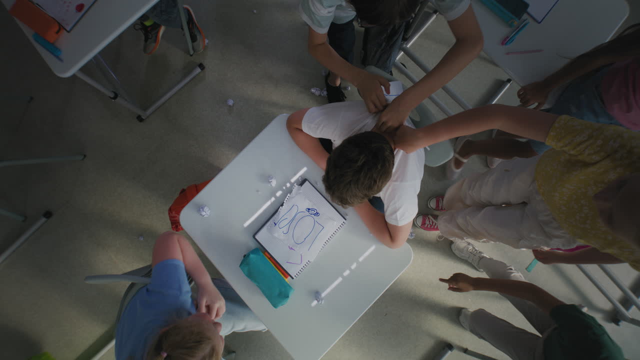 Classmates Bullying Stressed Elementary School Boy Sitting at Desk and Crying