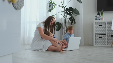 una joven madre progresista con dos hijos pequeños está hablando con su padre a través de la comunicación por video. la tecnología moderna es una familia joven.