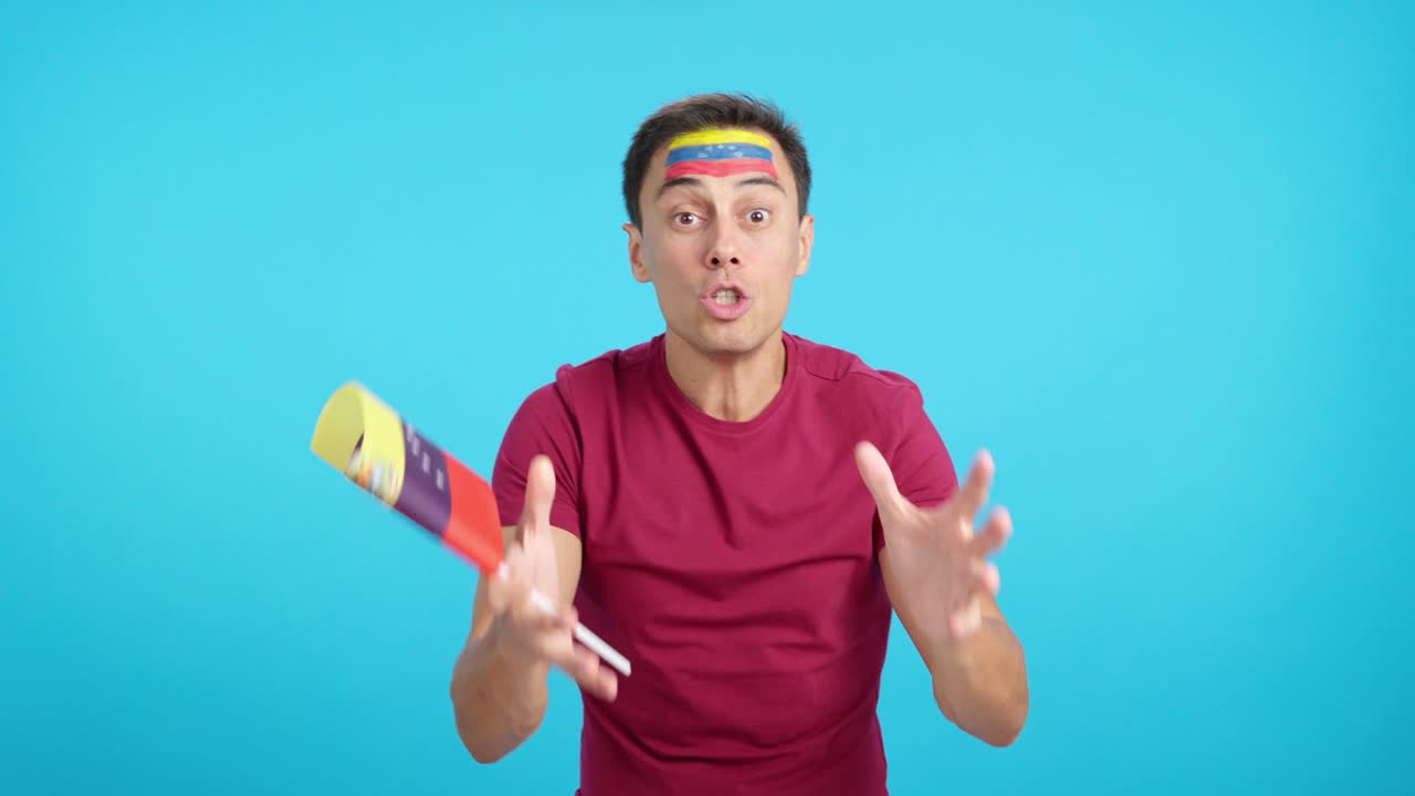 Man cheering for Venezuela screaming and waving a national flag