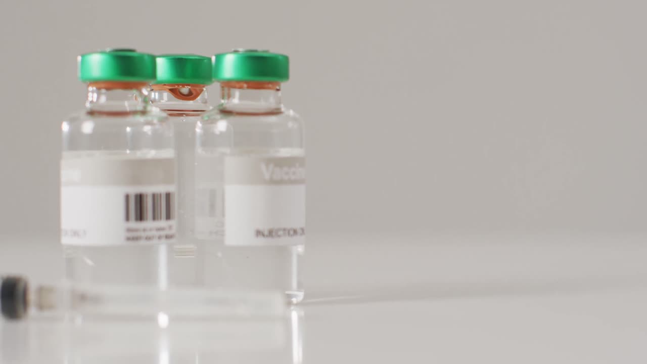 video de un primer plano de los viales de vacuna sobre un fondo blanco