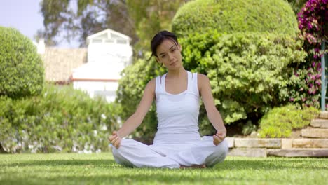 Gorgeous-young-woman-in-white-sitting-on-lawn