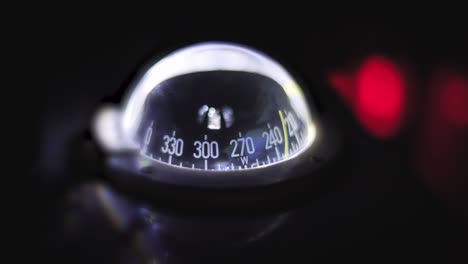 marine compass on a sailing yacht at night. backlit compass