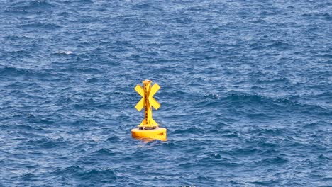 yellow buoy floating in the ocean waves