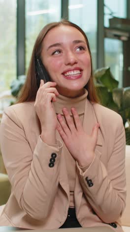 Happy surprised business woman in pleasant conversation phone call good news enjoying talking gossip