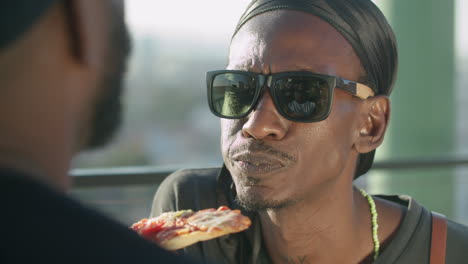 close-up shot of happy gay man eating pizza from lover's hands