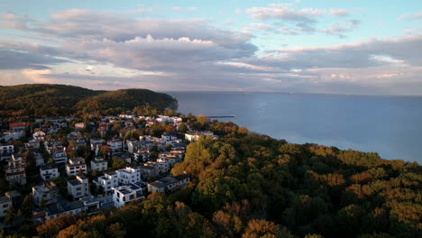 aerial drone view of kolibki neighborhood with dense autumn forest in gdynia-orłowo, poland