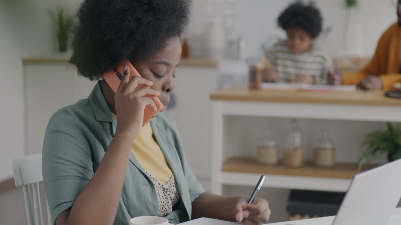 Woman working from home while children are present