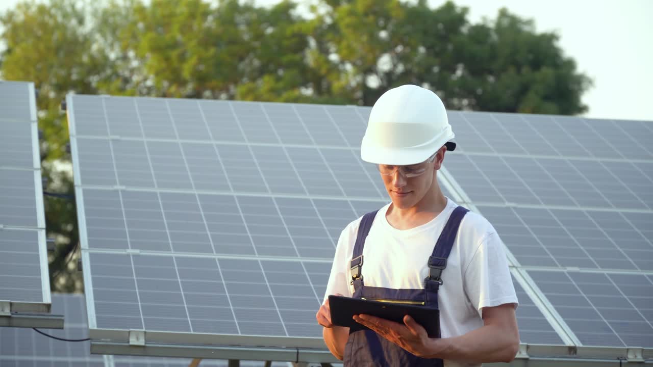 Solar panel technician working with solar panels. Engineer in a uniform with a tablet checks solar panels productivity. The future is today