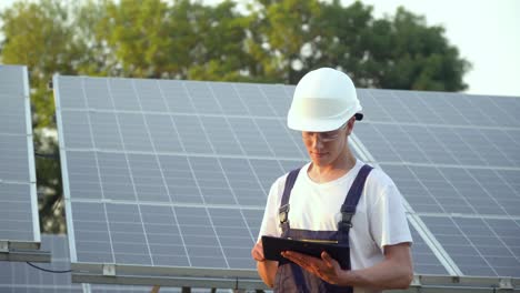solar panel technician working with solar panels. engineer in a uniform with a tablet checks solar panels productivity. the future is today