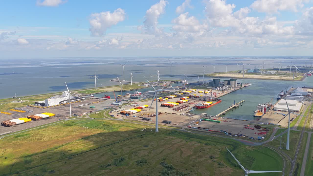 Vista aérea con dron de un puerto que almacena piezas de aerogeneradores marinos para su transporte.