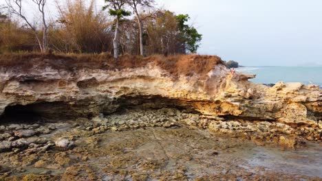 aerial: fly over a rocky cliff on the ocean