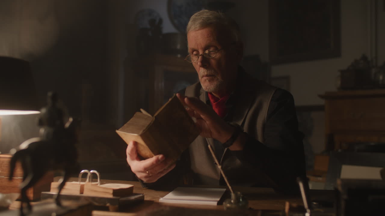 Old passionate man read a book in his office at night