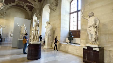 people exploring sculptures in the louvre museum