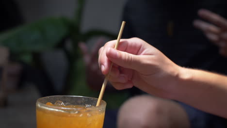 Hand-Placing-Biodegradable-Wheat-Straw-in-Drink---Environmentally-Friendly-Plastic-Alternative-Concept