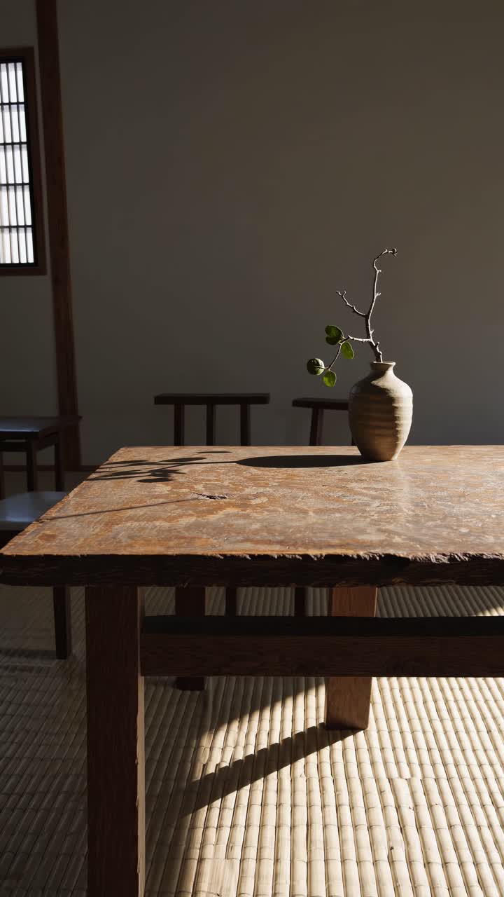 Interior minimalis dengan meja dan vas rustic, diambil dari sudut rendah
